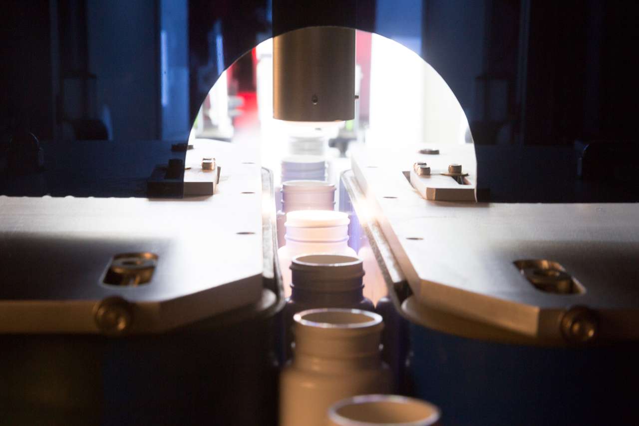 Bottles being fed into Optomech BIS inspection tunnel on production conveyor