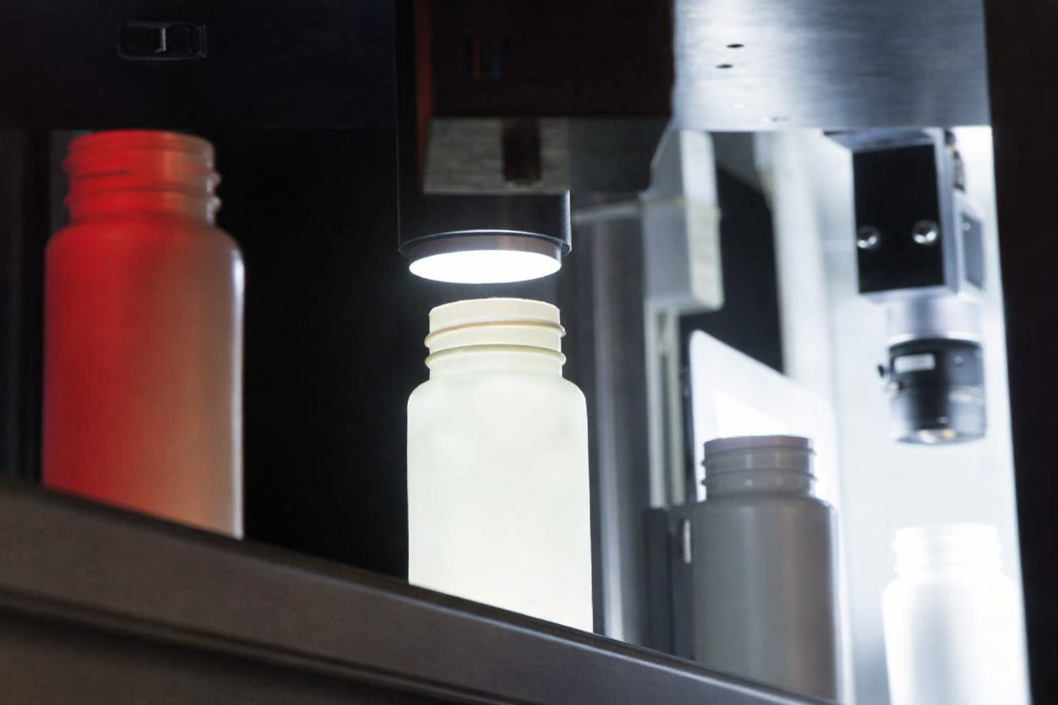 Optomech BIS in production line — bottles moving through inline inspection tunnel